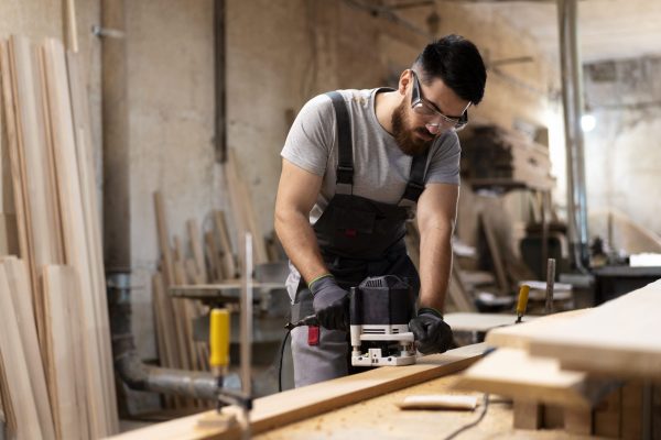 carpenter cutting mdf board inside workshop